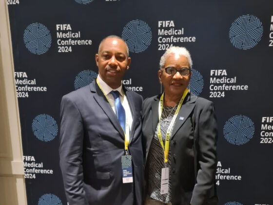 Standing in unity, Daniel Miller and Dr. Patti Symonette exemplify the Bahamas' commitment to advancing football healthcare at the FIFA Medical Conference 2024.